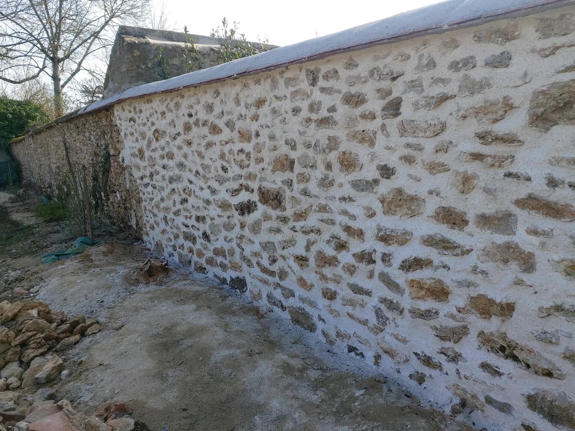 Mur en meulière décroûté sur toute sa longueur avant rejointoiement