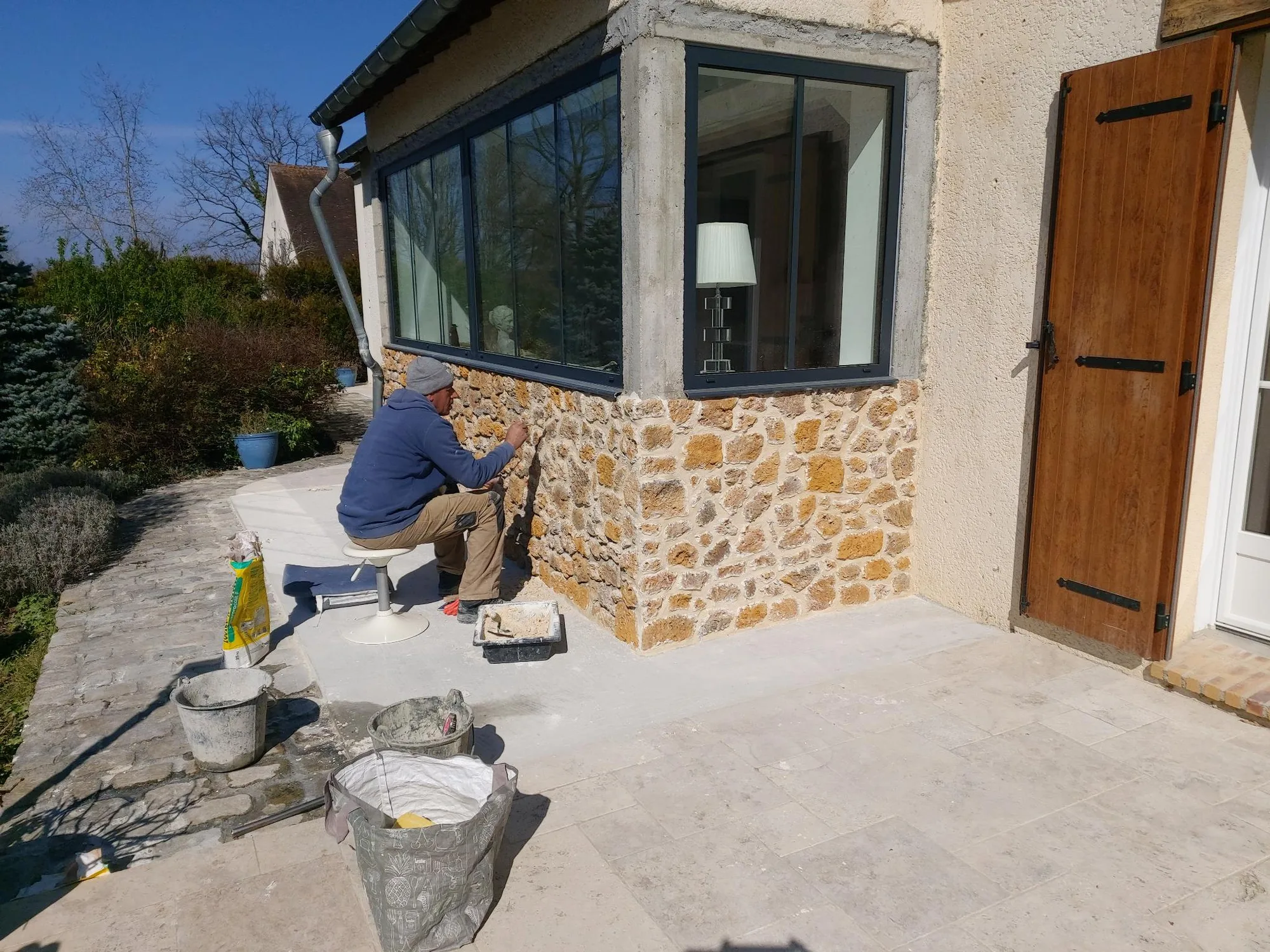 Maison ancienne rénovée mêlant soubassement en pierre apparente et grande baie aluminium