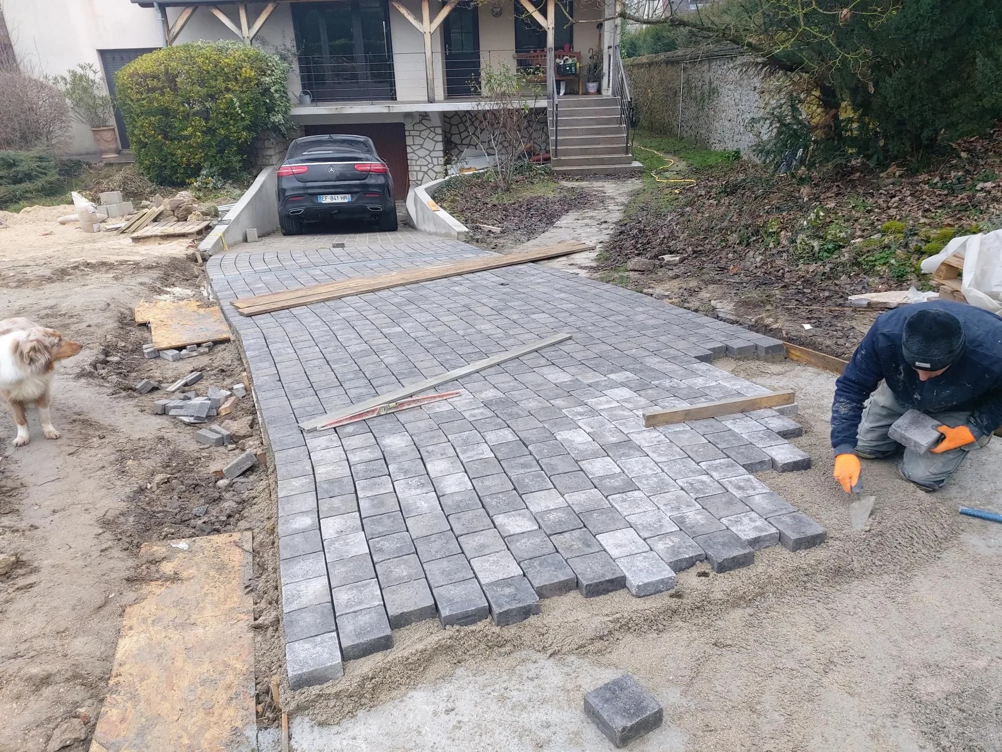 Pose de pavés en pierre sur une descente de garage